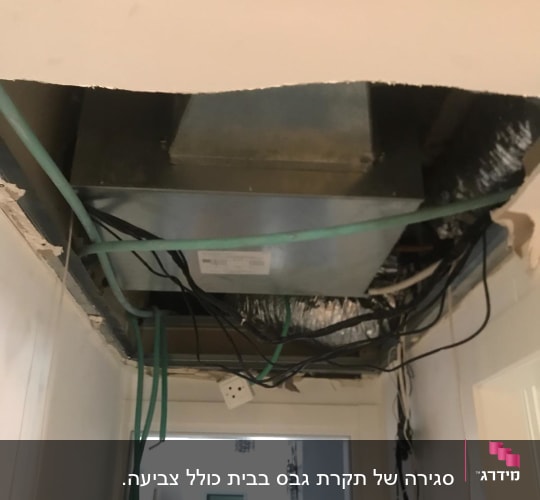 תקרה פתוחה עם חוטי חשמל וגבס חשוף